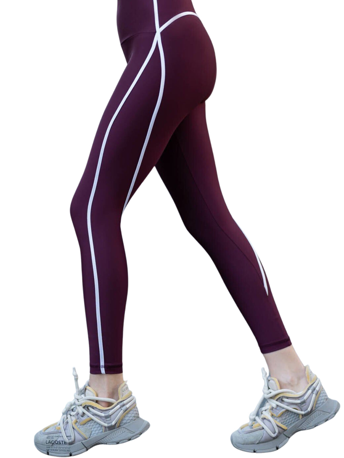 Eine Person trägt Lisminas 373 Menton Leggings in Dunkelviolett und graue Turnschuhe und geht vorwärts.